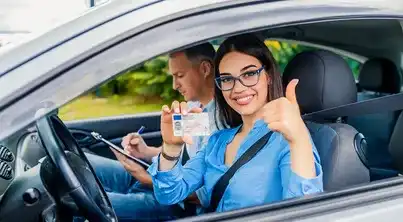 happy young woman holding her UK drivers License passed at the goodmayes driving test centre